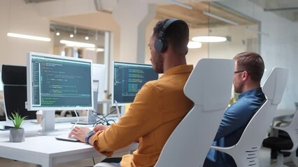 Wall Mural - side view of two multiethnic developers programming or testing computer programs. smart men working 