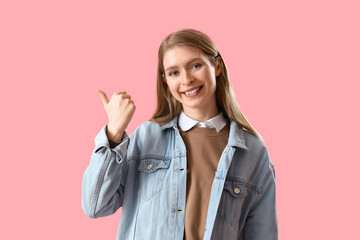 Sticker - Young woman pointing at something on pink background