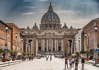 Perspektywa z poziomu ulicy Via della Conciliazione prowadząca bezpośrednio do majestatycznej Bazyliki Świętego Piotra w Rzymie. Starożytne budynki i historyczna atmosfera dodają uroku tej malowniczej