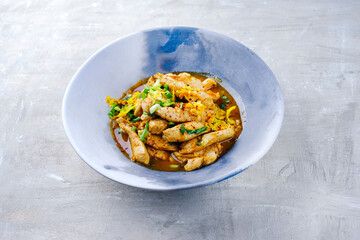 Wall Mural - Traditional chicken fillet with orange and spring onion in aromatic vegetable broth served as close-up in a design plate with text space