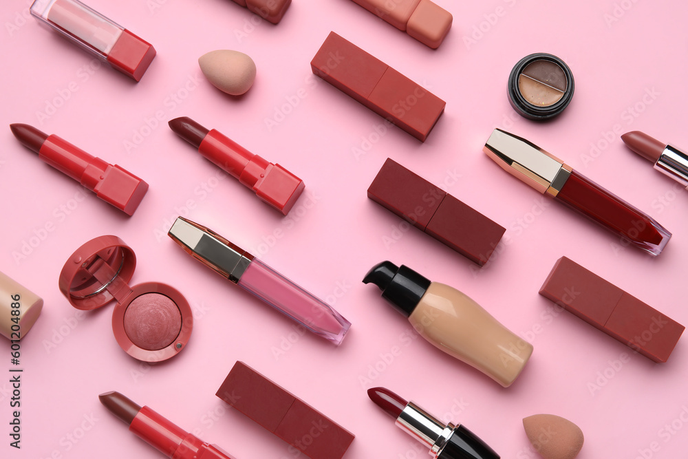 Decorative cosmetics with lipsticks and sponges on pink background