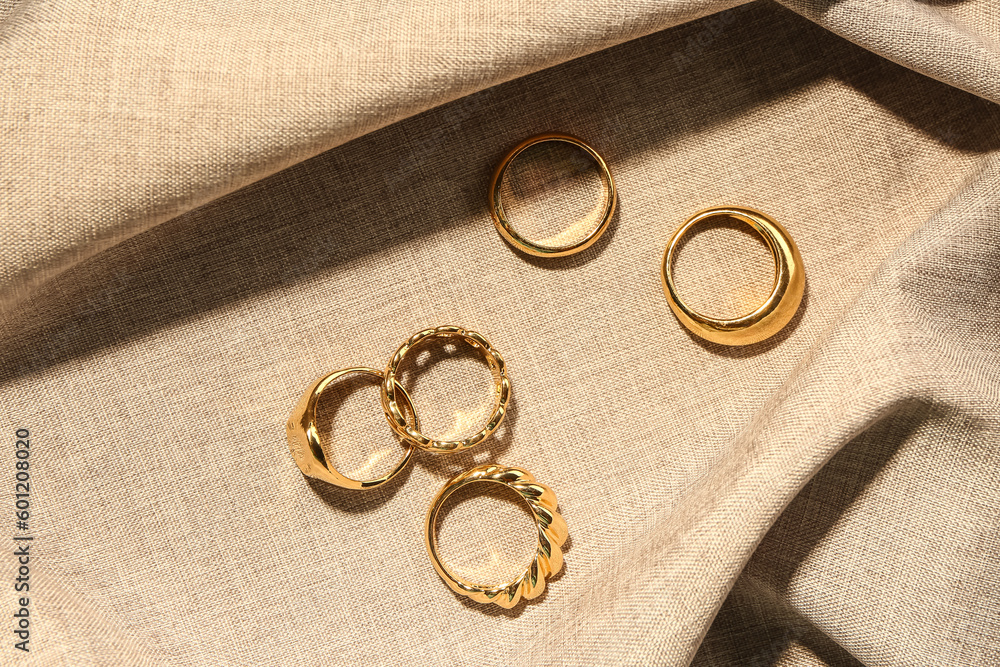Beautiful rings on beige fabric background