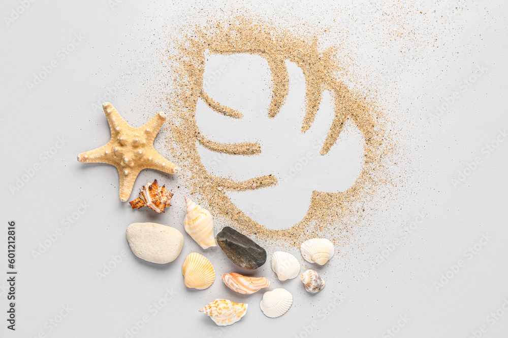 Palm leaf made of sand with starfishes and seashells on grey background