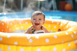 © Patrick - Happy baby playing in swimming pool during summer vacation. Generative Ai