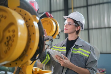 Robotic Arm engineer check on equipment in its with software of an Artificial Intelligence, .Female industrial engineer working at automated AI robotic production factory..