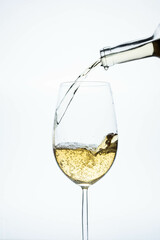 white wine glass with bottle pouring the liquid on a light background