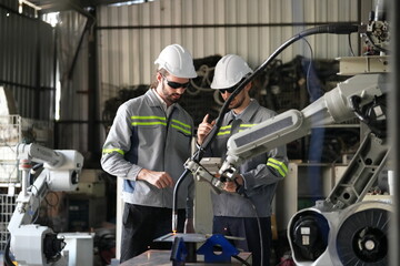 Wall Mural - Robotics engineer working on maintenance of robotic arm in factory warehouse. Business technology.