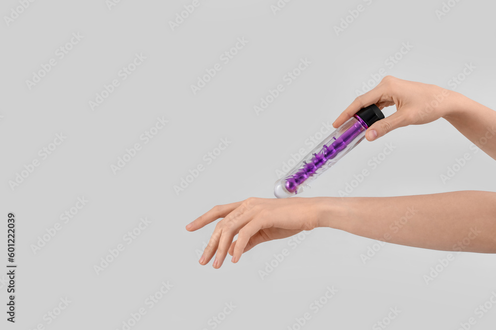 Woman with vibrator on light background
