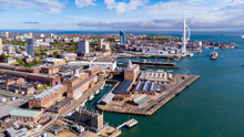 Aerial View Of Portsmouth Historic Dockyard And The Royal Navy's Ancient HMS Warrior Warship As Well As The Spinnaker Tower On The English Channel Coast In The South Of England, United Kingdom