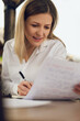 © kegfire - Positive female copywriter working with text on papers