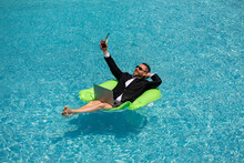 Freelance Work, Distance Online Work, E-working. Summer Business. Business Man In Suit Remote Working On Laptop In Pool. Business Man Working Online On Laptop In Summer Swimming Pool Water.