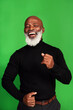 © Chanelle Malambo/peopleimages.com - Happy, dance and portrait of black man on green screen for celebration, music or excited. Happiness, smile and energy with senior person dancing isolated on studio background for freedom and movement