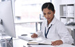 © Thaakirah/peopleimages.com - Medical research, young doctor with computer and notebook or paperwork sitting at her desk at work. Professional person, results and focused female worker reading paper with pc at her workplace
