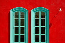 Abstract Image Of Green Windows On Red Wall.Green Windows On Red Wall And Sunlight, Shadow, Outdoor