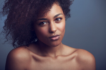 Wall Mural - African woman, curly hair and studio portrait with makeup, cosmetics and health by dark background. Girl, model and wellness with skincare, natural aesthetic and glow on face with beauty by backdrop