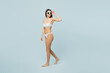 © ViDi Studio - Full body sideways young sexy woman wearing swimsuit sunglasses walking going look aside near hotel pool isolated on plain pastel light blue cyan background. Summer vacation sea rest sun tan concept.