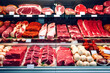 © niloo - Different cuts of fresh raw red meat in supermarket, variety of prime meat steaks, angus, T-bone, ribeye, striploin, tomahawk on display in a grocery store meat counter. generative ai
