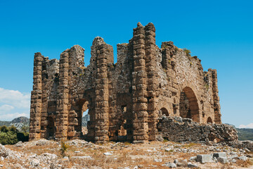 Wall Mural - Aspendos archaeological site featuring the well-preserved amphitheater and arches, buildings in Side, Antalya, Turkey.