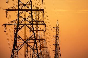 Wall Mural - High voltage electric transmission tower. High voltage power lines on electric pylon against a sunset sky. Electrical infrastructure. Energy crisis. Electric power distribution. Energy distribution.