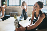 Fitness, gym and women stretching, exercise and workout goal for wellness, balance and stress relief. Female people, girls and athletes on the floor, stretch legs and smile with training and health