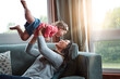 © Grady Reese/peopleimages.com - Mom, happy and lifting girl on sofa in home living room and relax, bonding and quality time together or mother, love and family happiness. Child, mommy and playing game on couch in house with smile