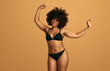 © kegfire - Cheerful black plus size woman wearing lingerie dancing in studio