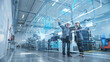 © Gorodenkoff - Factory Digitalization: Two Industrial Engineers Use Tablet Computer, Visualize the Wall of Big Data Statistics, Optimization of High-Tech Electronics Facility. Industry 4.0 Machinery Production