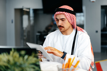 Wall Mural - Arab muslim businessman using digital tablet in modern office