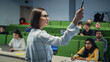 © Gorodenkoff - Excited Female Teacher Giving Lecture to a Diverse Multiethnic Group of Students in a Modern College Room. Involved and Thoughtful Scholars Studying and Listening to Lecturer. Camera Facing Class