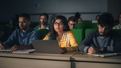 Fototapete - Portrait of a Smart Beautiful Indian Female Student Studying in University with Diverse Multiethnic Classmates. Young Woman Using Laptop Computer and Taking Notes During the Lecture