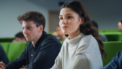 Fototapete - Talented Smart Female Student Studying in College with Diverse Multicultural Colleagues. Young Woman Focused on a Lecture, Writing Down a Summary in Her Notebook