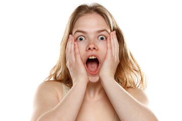 Portrait of young beautiful shocked blonde woman with no makeup on white background