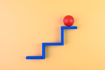 Concept of success. Wooden ball placed on the top step.