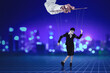 © Creativa Images - Puppeteer holding businesswoman on strings