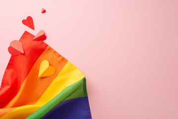 Wall Mural - A top-down view of LGBT History Month arrangement idea with rainbow flag and colorful hearts, on a pastel pink background, and a blank space for text or promotional purposes