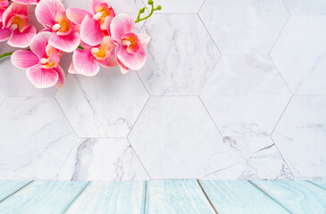 The Wooden floor and marble wall with pink color orchid decorate, empty room for background.