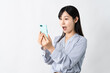 © aijiro - スマートフォンを持ちながらビックリをする若い女性