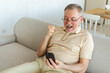 © Юлия Завалишина - Middle aged senior man euphoric winner with smartphone. Older mature grandfather looking at cell phone reading great news getting good result winning online bid feeling amazed. Winning gesture