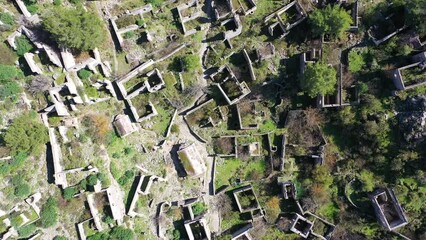 Wall Mural - Drone view on Kayakoy ghost town near to Oludeniz, Fethiye. The old ancient city on the beautiful green slope of the hill.