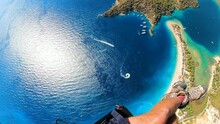 Paragliding Point Of View In Oludeniz. Legs Paraglider Flying Over The Sea And The Beach On Sunset. Extreme And Active Types Of Recreation. Panoramic View From Gopro. High Quality FullHD Footage