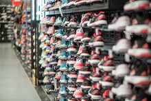 Shop Display Of A Lot Of Sports Shoes On A Wall. A View Of A Wall Of Shoes Inside The Store. Modern New Stylish Sneakers Running Shoes For Men And Women - Dubai UAE December 2019. High Quality Photo