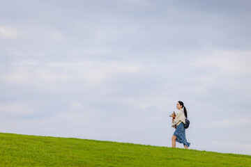 Sticker - Woman with her dachshund dog walking in the park