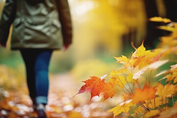 Woman alone walks in the sunny autumn season park. Selective focus