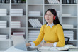 © Tj - Young Asian female student, study in the school library. She is using laptop and learning online.