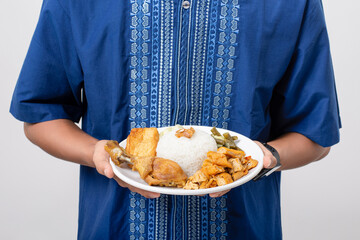 Wall Mural - Young muslim man volunteer holding and sharing food for other person isolated on white background. Concept of alms, food sharing and help each other.