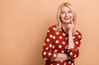 © deagreez - Photo of cheerful minded aged lady toothy smile finger touch lips look empty space isolated on beige color background