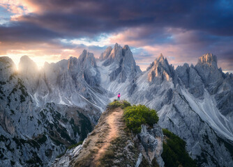 Wall Mural - aerial view of girl on the mountain peak and rocks at colorful sunset in summer. tre cime, dolomites