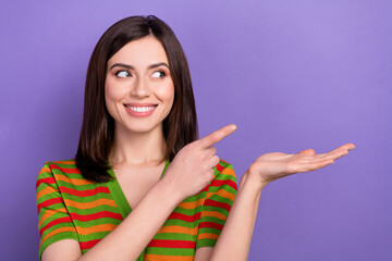 Sticker - Photo of friendly woman straight hairstyle wear colorful t-shirt indicating look at sale on palm empty space isolated on purple background