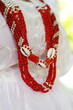 Detalhe de colar guia da umbanda, símbolo de orixá com missangas vermelhas e brancas no terreiro do centro religioso.