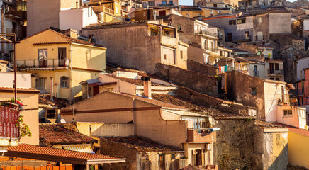 scenic view of historical center of a city with old vintage yellow buildings and houses with orange tiled roof and beautiful blue sky on background